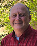 Picture of Charles W. Kaspar dressed in red plaid shirt in front of tree