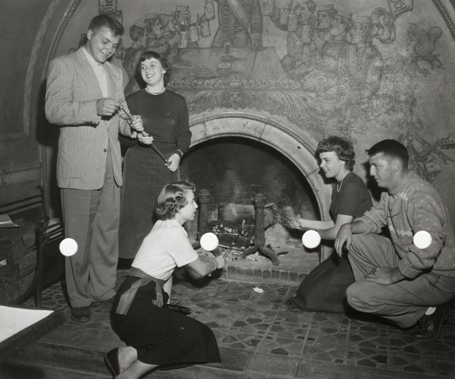 Photo of students roasting hot dogs at the Memorial Union fireplace