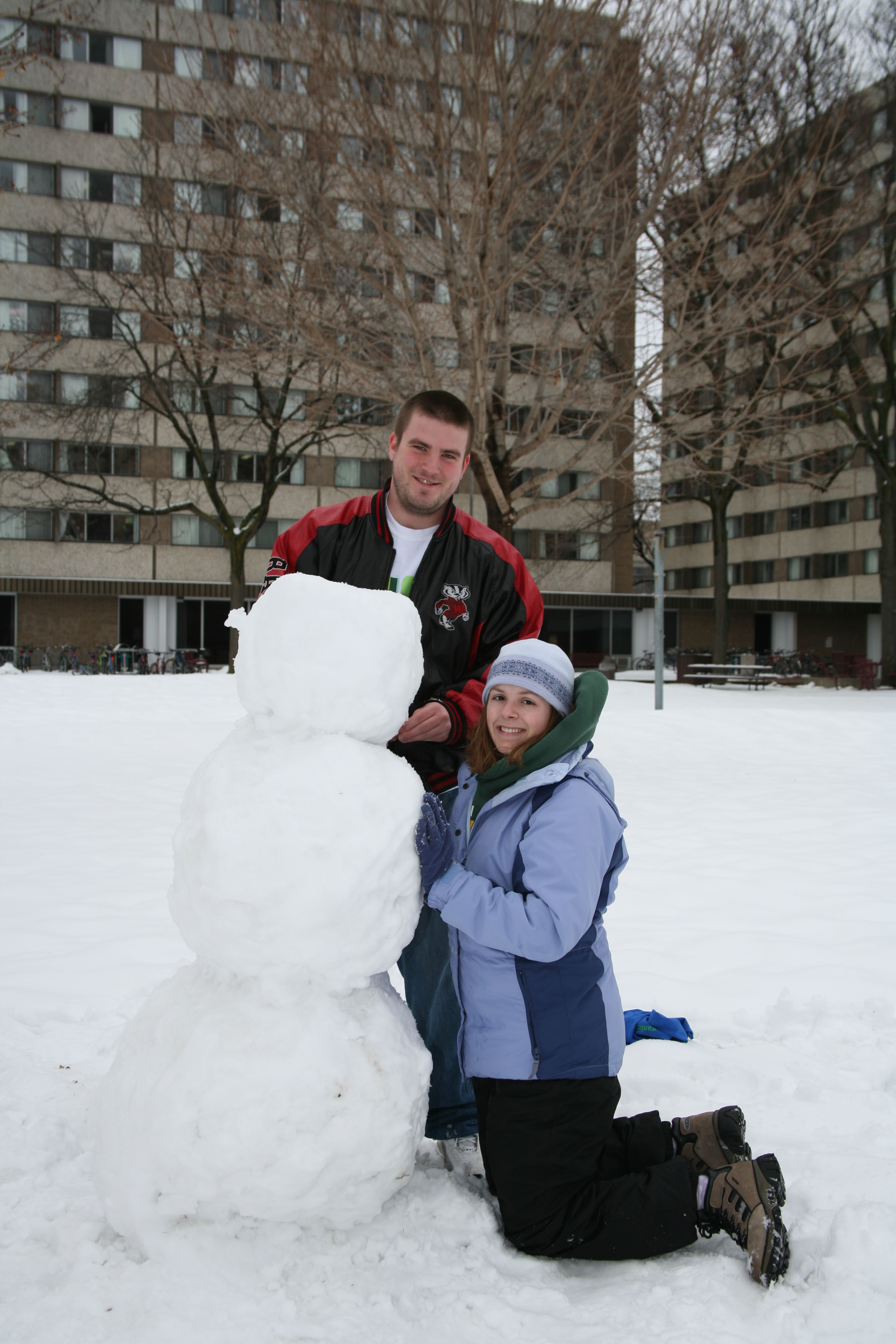 Two students building a snowman outside Sellery Residence Hall in 2006