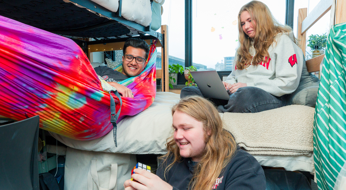 Three students relaxing in a residence hall room