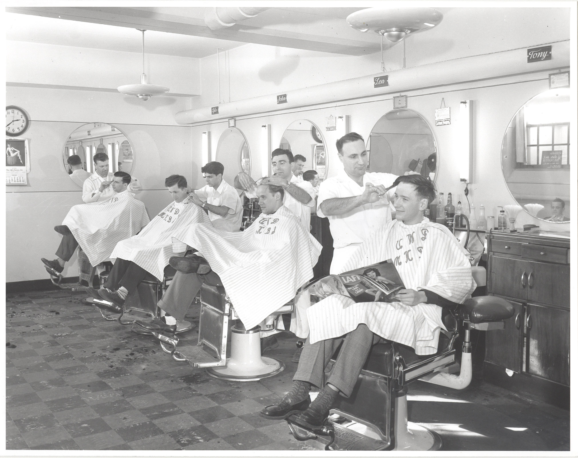 Students getting their haircut in barber's chairs