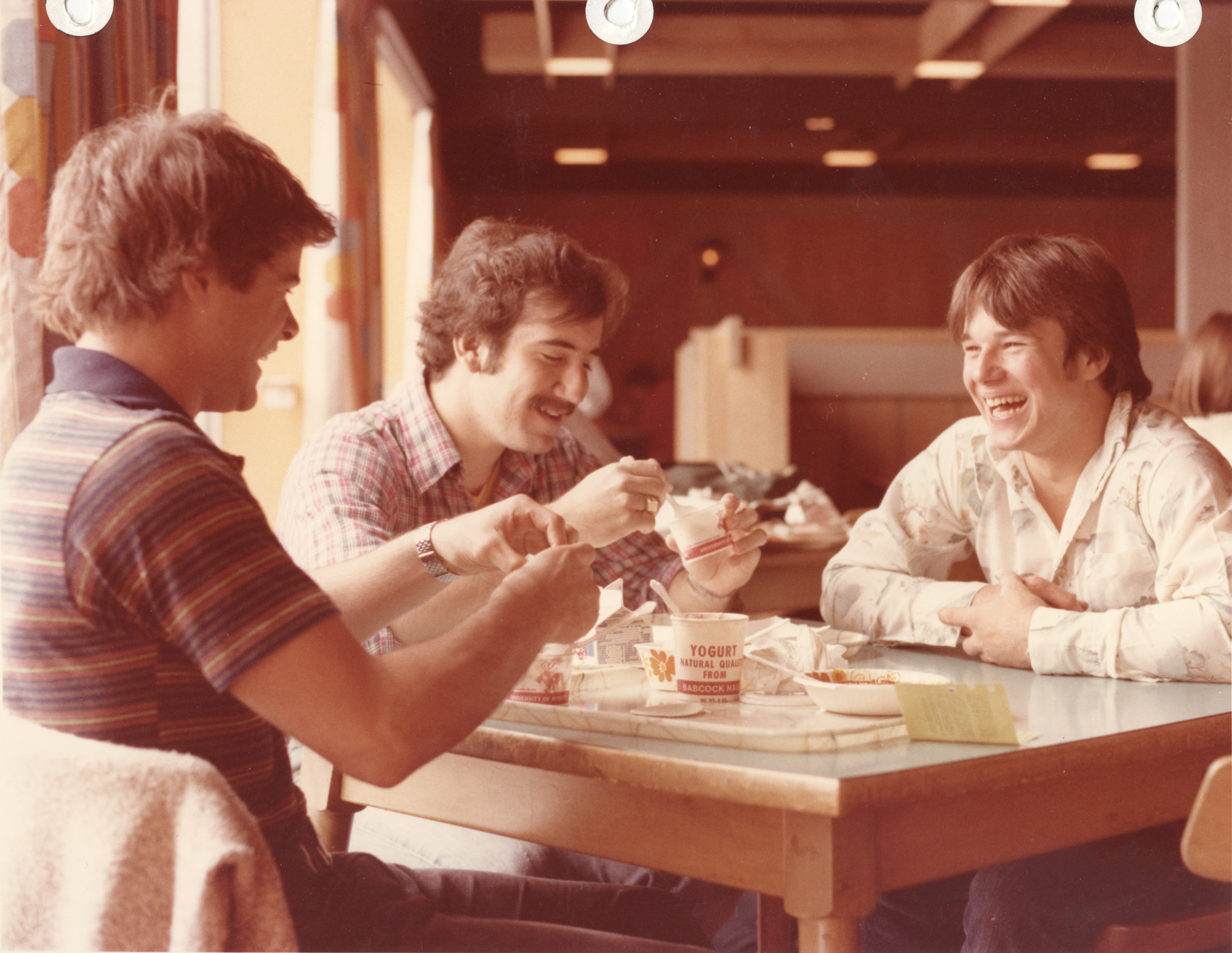 Students laughing and eating breakfast at a dining hall
