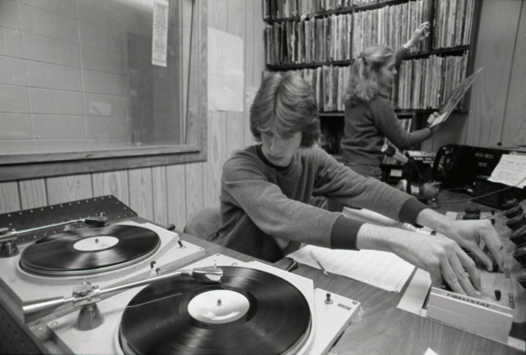 Two students sit behind turntables