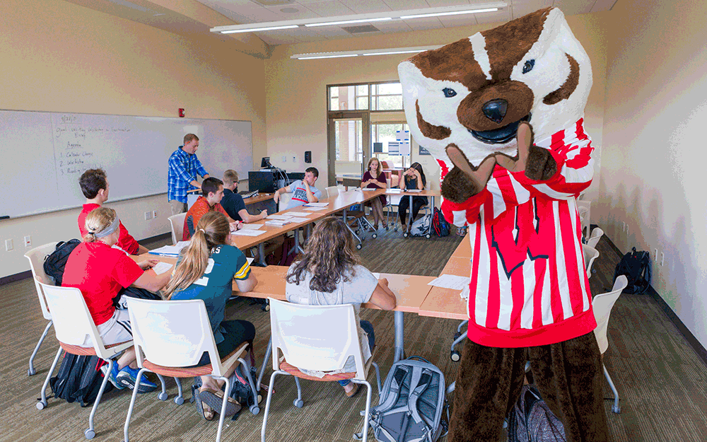 Bucky Badger poses for a photo while making a W with his hands with text overlaid reading "Built for your success."