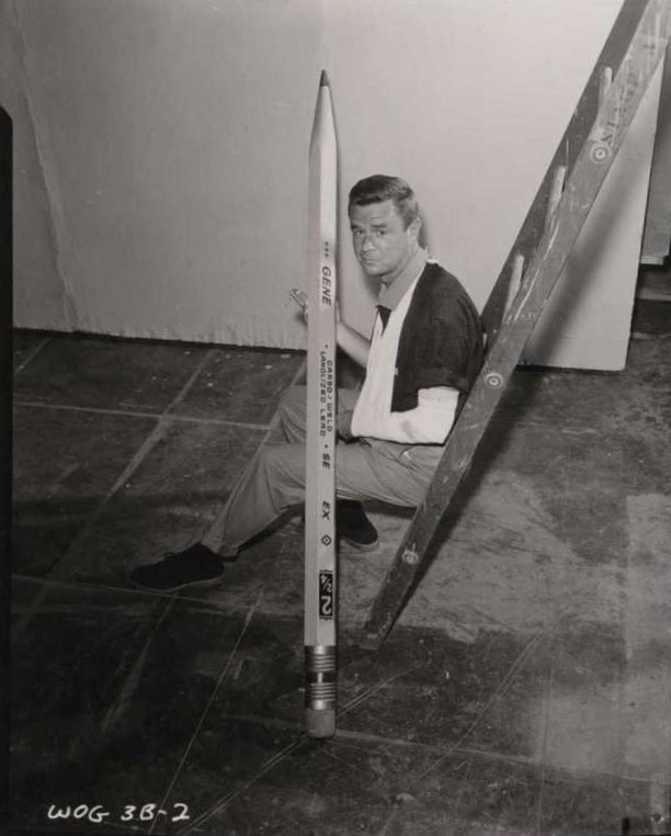 An actor from the show World of Giants holds a giant pencil prop. 