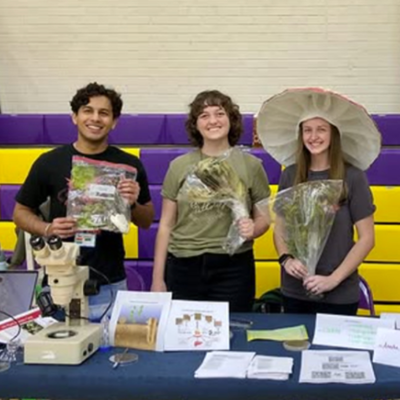 3 graduate students providing plant disease outreach to school age children.