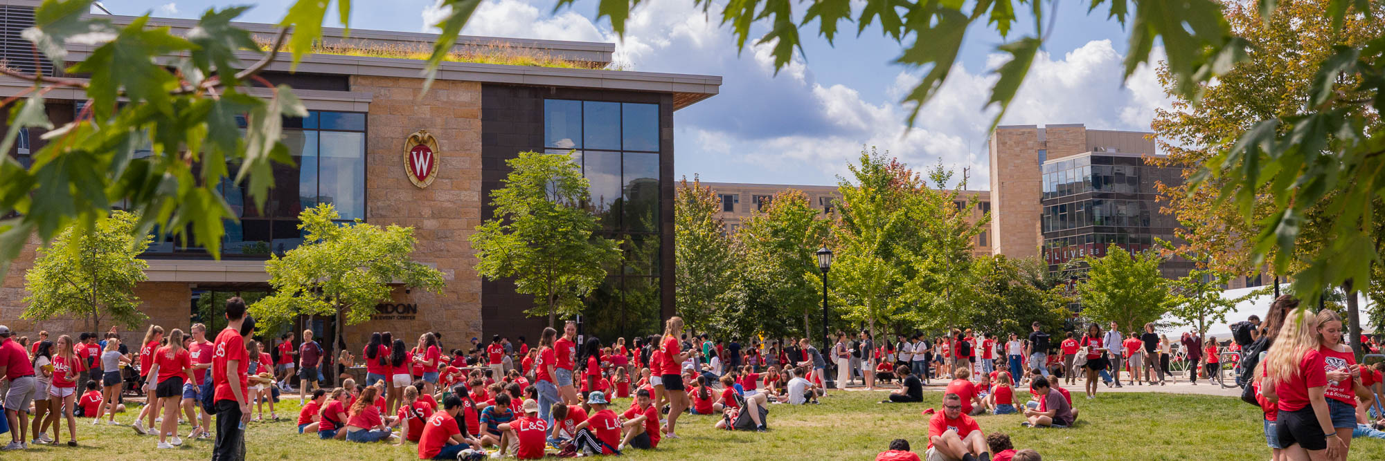 A wide photo of students outside Gordon Dining & Event Center eating lunch